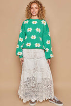 Load image into Gallery viewer, Woman wearing green daisy sweater with drop shoulder design, styled with a white lace skirt, showcasing trendy winter clothes for women.
